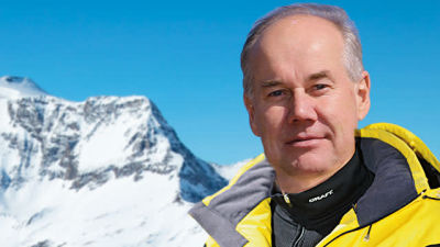 Harri Kaijanto, Finlandschef för Alppimatkat, med alplandskap i bakgrunden.  