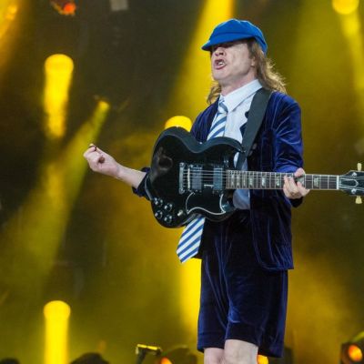 Kitaristi pukeutuneena koulupoika-asuun