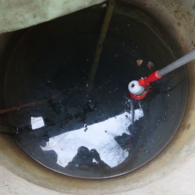 Kaivosta otetaan vesinäytettä pulloon.