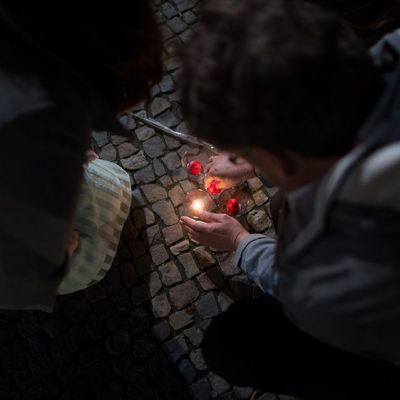 Ihmiset sytyttävät kynttilöitä Pariisissa menehtyneiden muistolle Berliinissä Ranskan suurlähetystön ulkopuolella.
