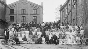 Arbetare vid Ensos fabrik fabrikasarbetare på gruppbild på historiskt fotografi utanför Ensos fabrik