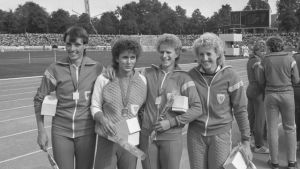Bärbel Wöckel, Marlies Göhr, Ingrid Auerswald och Ines Schmidt (nuvarande Geipel) år 1984 efter att ha tagit världsrekord. Fyra kvinnor i idrottskläder håller varandra om axlarna och ler mot kameran. Bilden är svartvit.