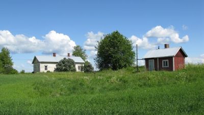 Hus på landsbygden i sommarlandskap.