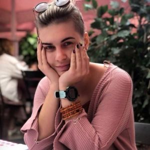 Anna Formina och hennes kollegor på OVD-info ringer dagligen upp tiotals personer vars fall tas upp i rätten dagen efter. Kvinna i rosa tröja lutar ansiktet i händerna och ler mot kameran.