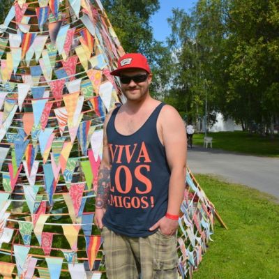 Qstock-talkootyöntekijä Samu Manninen seisoo festivaalialueella tiipiin edessä.