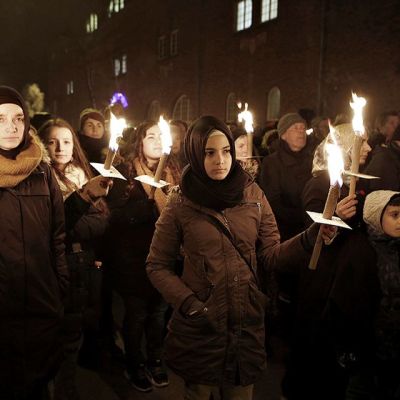 Joukko naisia seisoo soihdut kädessä