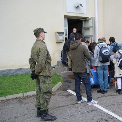 Pihanvalvoja seuraa turvapaikanhakijoiden rekisteröitymistä Tornion järjestelykeskuskessa.