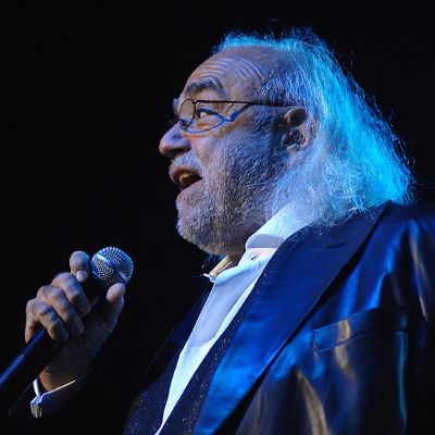 Demis Roussos laulaa sinisävyisessä kuvassa vuonna 2009.