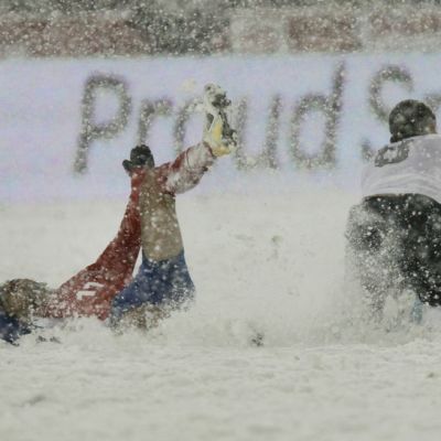 Costa Rican Michael Barrantes (vas.) kaatuu lumen peittämällä kentällä. Vieressä nurin myös Yhdysvaltain Clint Dempsey (oik.).