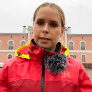En kvinna som står framför Lovisa stadshus.