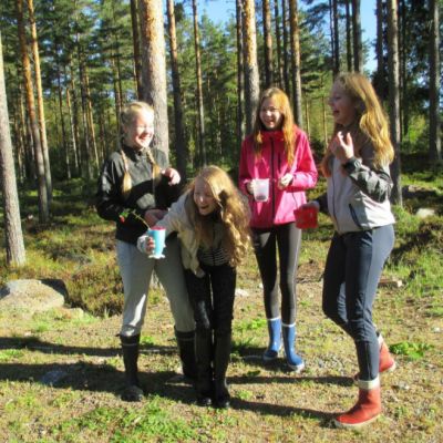 Kuvassa neljän nuorta metsässä.