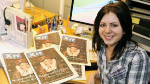 Redan som 16-åring började Zandra jobba som nöjesreporter på Ålandstidningen. Några år senare var hon chefredaktör för tidningen XIT. Zandra Lundberg med mörkt hår vid skrivbord.