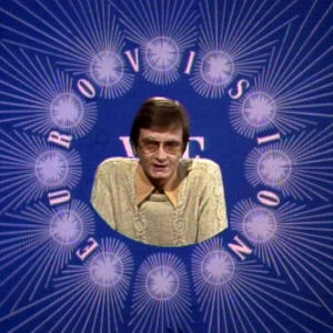 Toimittaja Matti Rosvall suomii Euroviisuja. Matti Rosvall juontaa Tasavallassa tapahtuu -ohjelmaa Eurovisio-tunnuksen sisällä 1976.
