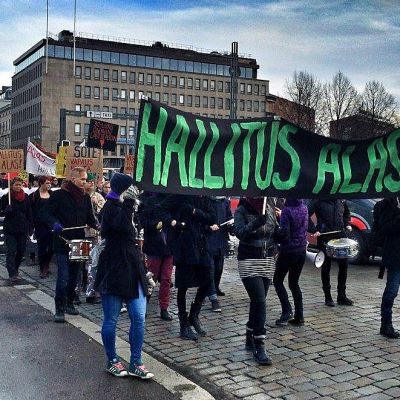 Useita kymmeniä mielenosoittajia marssii Tampereen Hämeensillalla. Suurimassa banderollissa lukee "hallitus alas".