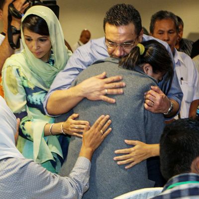 Malesian puolustus- ja liikenneministeri Hishammuddin Hussein halasia kadonneessa lentokoneessa matkustaneiden omaisia Putrajayassa 29. maaliskuuta.