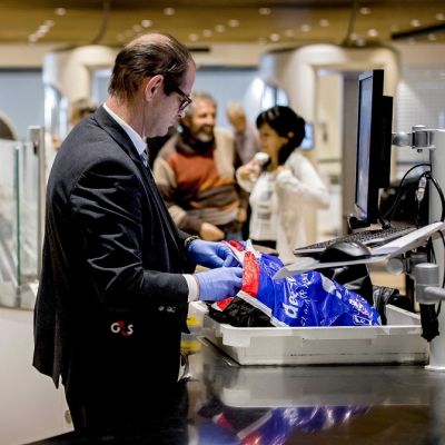 Turvatarkastaja tutkii matkatavaroita laitteella