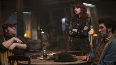 Horace (Paul Walter Hauser), Estella (Emma Stone) och Jasper (Joel Fry) sitter runt ett bord.