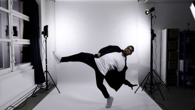 Julian Owusu dansar i en vit fotostudio.