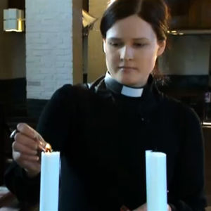 Pappi Mari Leppänen sytyttää kynttilää kirkossa, ohjelmasta A-Studio 6.3.2012