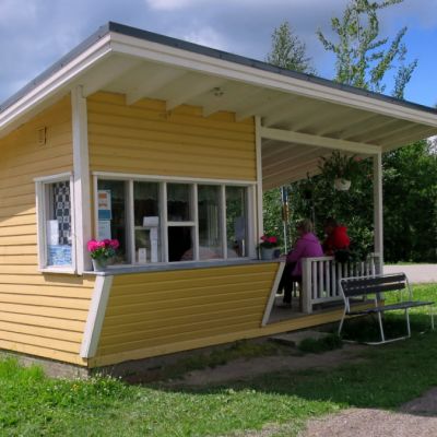 Keltainen puukioski säteilee auringoinvalossa