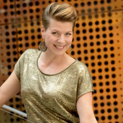 Laulaja Heidi Kyrö seisoo Verkatehtaan portaissa ja katsoo kameraan