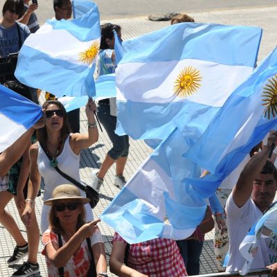 Ihmiset heiluttavat Argentiinan lippuja ja Mauricio Macrin kuvalla varustettua lippua.
