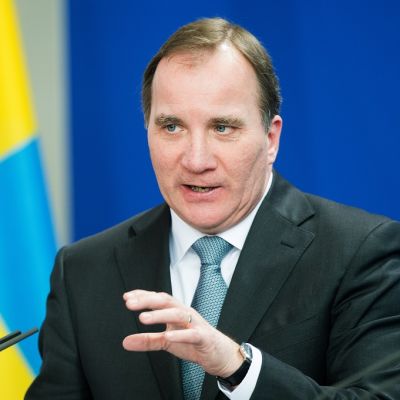 Puolikuva Löfvenistä tummassa puvussa. Taustalla Ruotsin lippu.