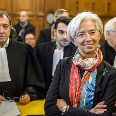 Lagarde seisoo oikeussalissa kädet puuskassa ja hymyilee. Hänellä on kaulassaan värikäs huivi. Taustalla näkyy oikeuden jäseniä.
