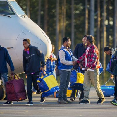 Eritrealaisia turvapaikanhakijoita Luulajan lentokentällä lentokoneen edustalla.