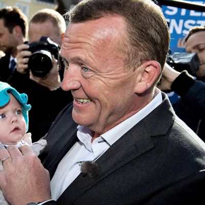 Venstre-puolueen johtaja Lars Loekke Rasmussen poseeraa kuvaajille vauva sylissään.