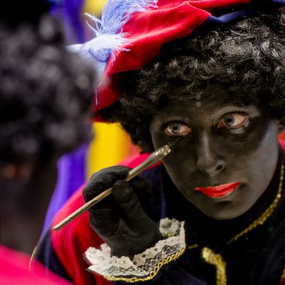 Zwarte Pietiä esittävä näyttelijä maalaa naamaansa mustaksi.