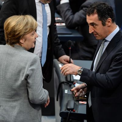 Merkel ja Özdemir puhuvat toisilleen ilmeet vakavina.