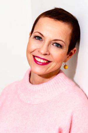 Arja Ryynänen valde att byta parti från Centern till Samlingspartiet. En kvinna ler och ser in i kameran.