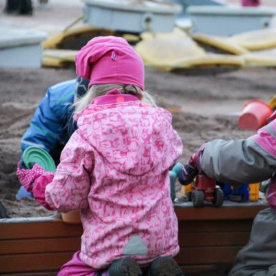 Lapsia tarhassa hiekkalaatikolla.