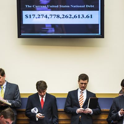 Edustajainhuoneen työntekijöitä Washingtonissa tiistaina, yläpuolellaan Yhdysvaltain velan määrän reaaliaikaisesti osoittava näyttö.