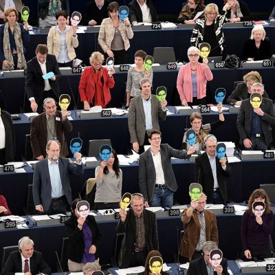 Eu parlamentin jäsenet nostavat Snowden-maskit ylös äänestäessään täysistunnossa Strasbourgissa keskiviikkona 12. maaliskuuta 2014.