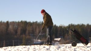 Golffaaja talvisella golfkentällä.