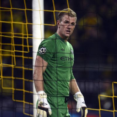 Manchester Cityn Joe Hart katselee maaliverkon läpi.