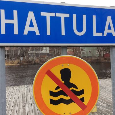 Hattula-kyltti ja uimisen kieltävä liikennemerkki