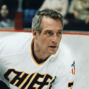Harmaatukkainen näyttelijä Paul Newman jääkiekkoilijana Chiefs-joukkueen pelipaidassa elokuvassa Lämäri.