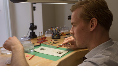Urmakare Eric Wikman putsar en gammal klocka