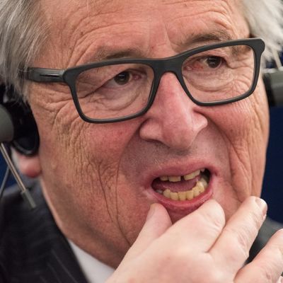 Jean-Claude Juncker kuulokkeet päässään.