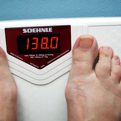 Henkilö vaa'alla, jonka lukema on 138 kiloa.