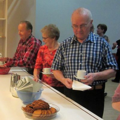 Ihmisiä ottamassa kahvia eläkeläisten päivätansseissa.