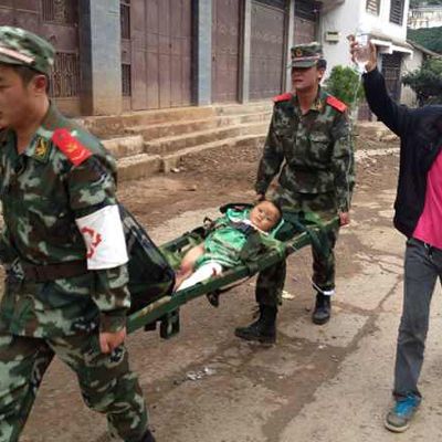 Maanjäristyksessä loukkaantunutta lasta kannettiin hoitoon Yunnanin maakunnassa sunnuntaina.