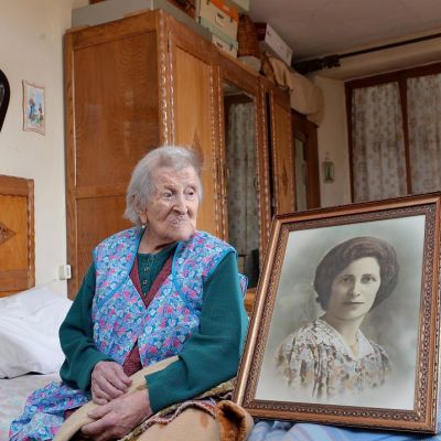 Emma Morano istuu sängyllä ja katsoo kuvaa, joka esittää häntä nuorena Verbaniassa, Pohjois-Italiassa.