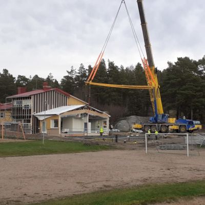 Lyftkran lyfter huselement på plats i Houtskär. 