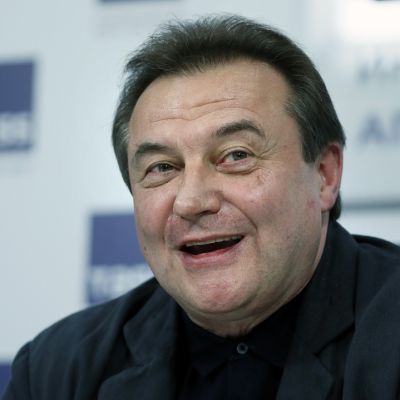 Aleksei Utšitel hymyilee tiedotustilaisuudessa.
