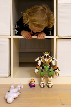 Kaapo-pikkupoika kurkistaa hyllystä, etualalla lego-ukko
