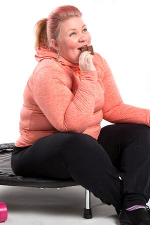 Jenny Lehtinen istuu trampoliinilla ja syö suklaata